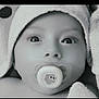 baby, infant, pacifier, towel, hood, close_up, black_and_white, face, wide_eyes, skin, cute, newborn, child, soft_texture, wrapped, portrait, expression, innocent, young, person