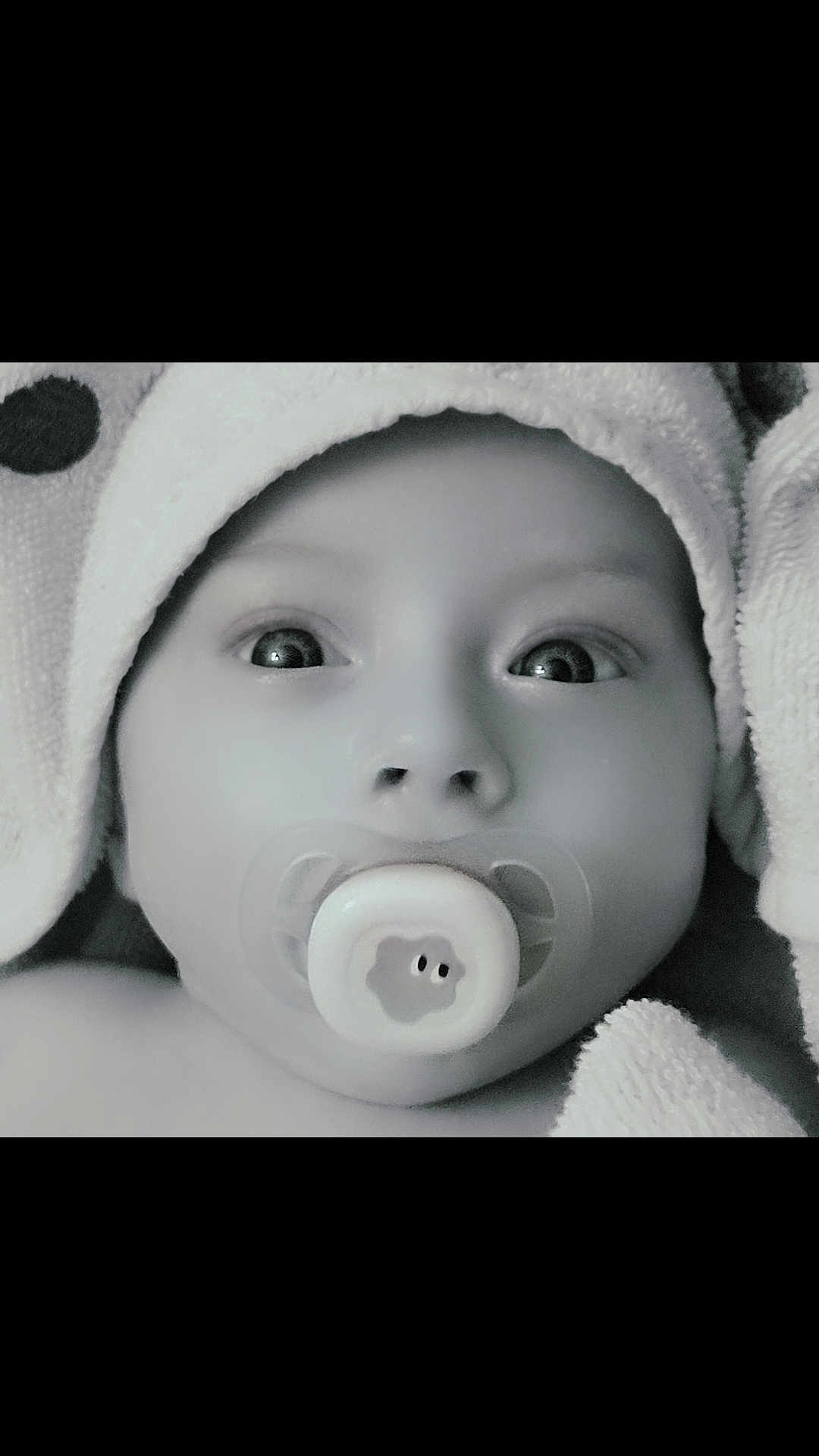 Livio participe au concours pour gagner de l'argent avec cette photo : baby, infant, pacifier, towel, hood, close_up, black_and_white, face, wide_eyes, skin, cute, newborn, child, soft_texture, wrapped, portrait, expression, innocent, young, person