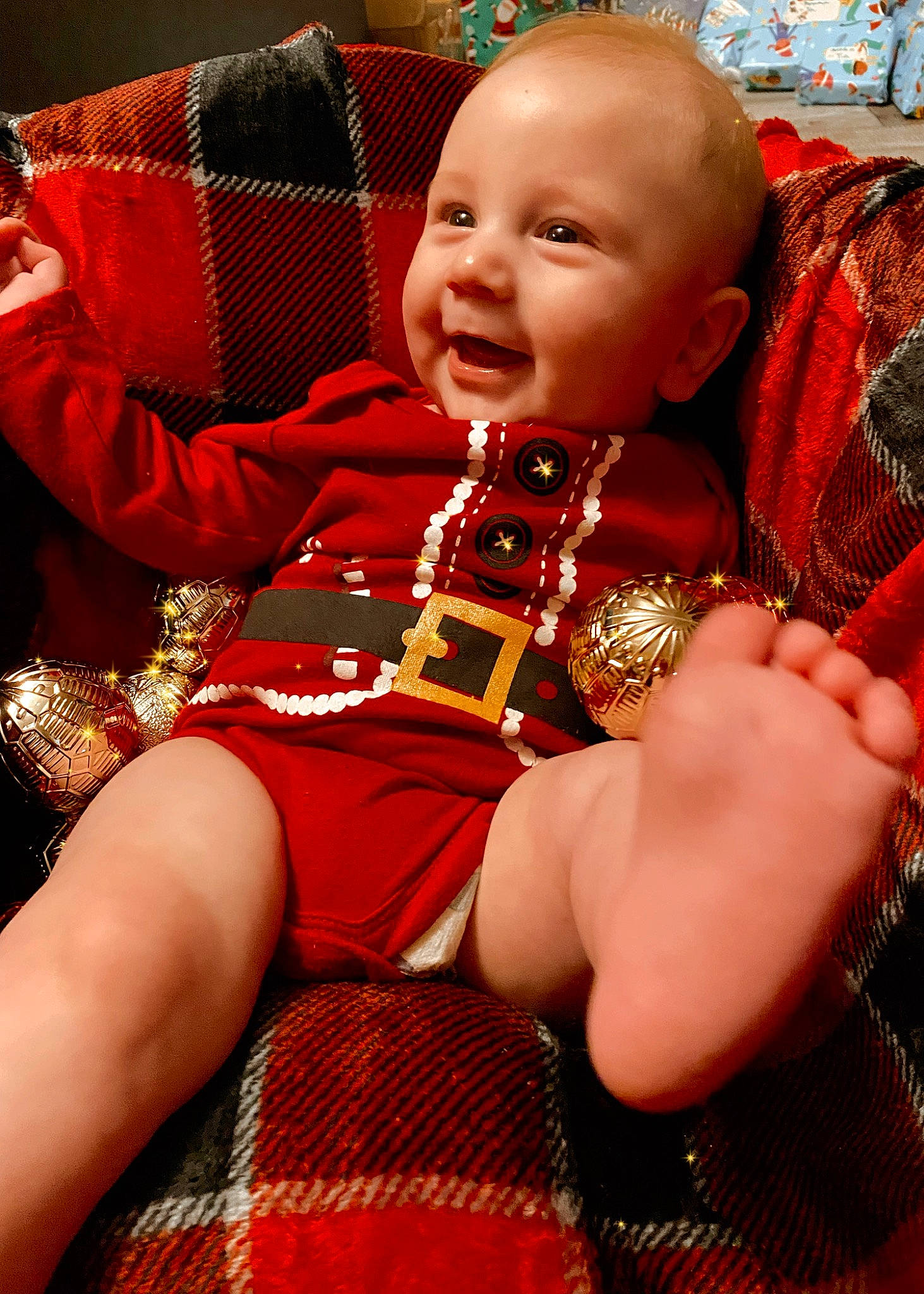 Achilles is registered to the contest to win money with this photo: baby, baby_toddler_clothing, carmine, cheek, child, event, eye, fun, happy, head, human_leg, lap, pattern, person, red, sitting, skin, sleeve, smile, thigh