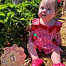 baby, child, red_clothing, gingham, strawberry, outdoor, garden, plants, greenery, sunlight, straw, sign, age_marker, pink_shoes, cute, portrait, sitting, people, summer, nature