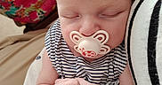 Camélia a rejoint le concours — aidez-le/la à gagner de superbes lots ! baby, child, close_up, comfort, cuddle, cute, floral_background, hand, heart_pattern, indoors, infant, nap, pacifier, peaceful, person, portrait, sleeping, soft_skin, striped_clothing, striped_garment