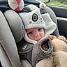 baby, car_interior, car_seat, child, child_safety, cozy, cute, face, hooded_clothing, indoors, infant, looking, panda_hood, plush_toy, portrait, rain, seatbelt, soft_toy, warm_clothing, window