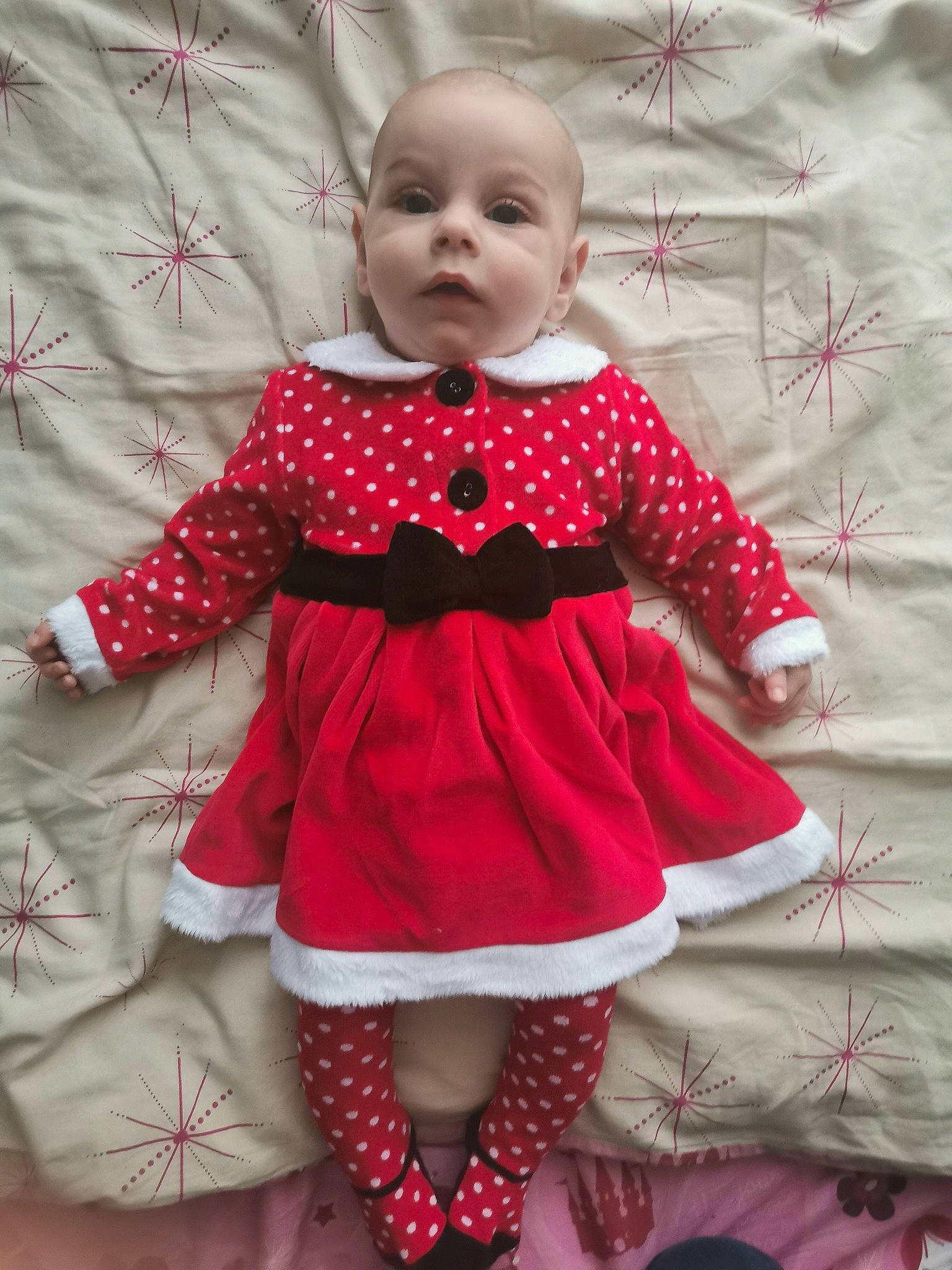 Amy participe au concours pour gagner de l'argent avec cette photo : arm, baby, baby_toddler_clothing, child, day_dress, dress, face, hand, human_body, leg, magenta, one_piece_garment, pattern, person, pink, red, sitting, sleeve, sock, toddler
