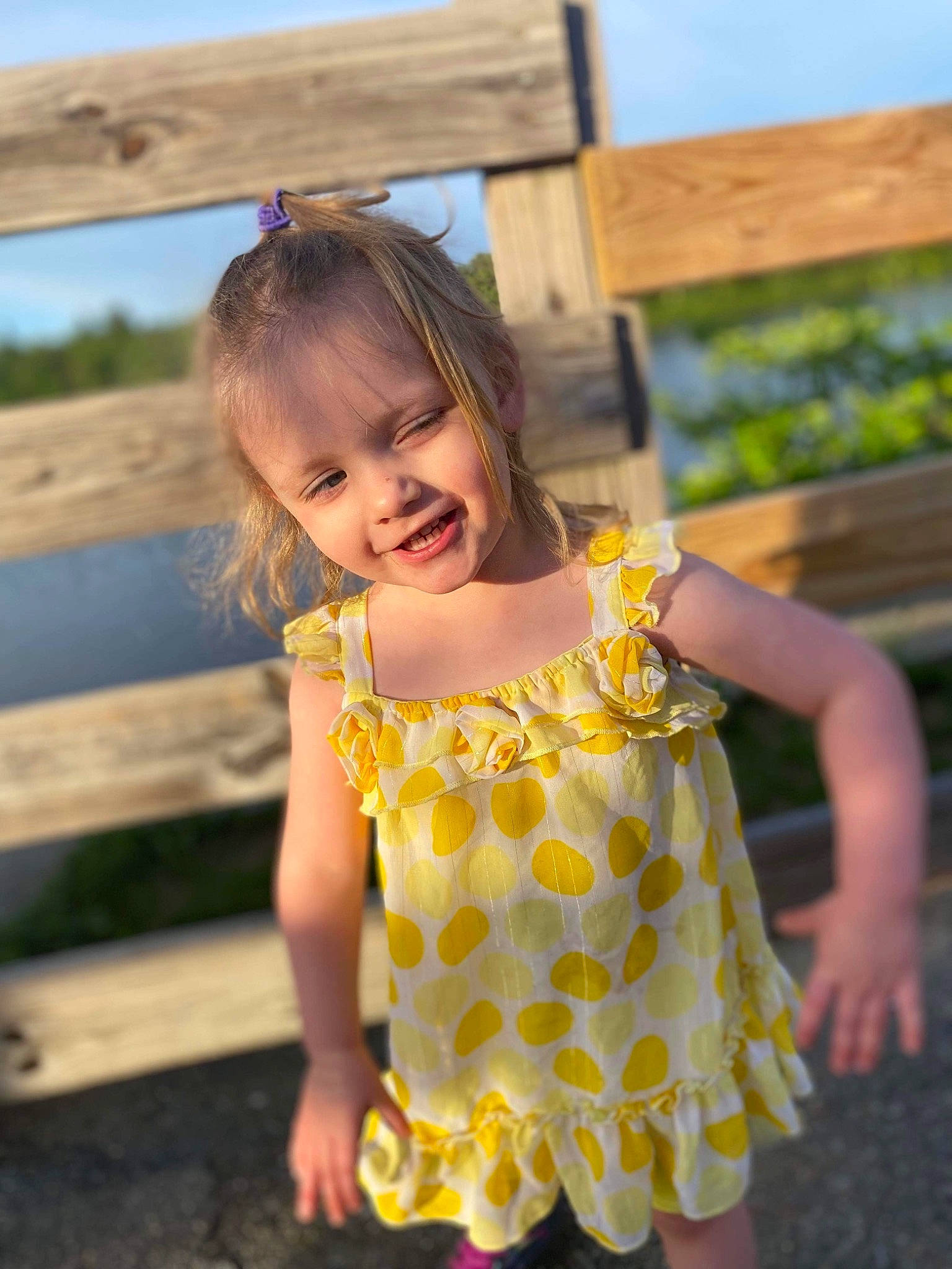 Khloe is registered to the contest to win money with this photo: baby_toddler_clothing, child, dress, eye, facial_expression, flash_photography, fun, grass, happy, head, leisure, people_in_nature, person, plant, skin, sky, smile, standing, sunlight, toddler