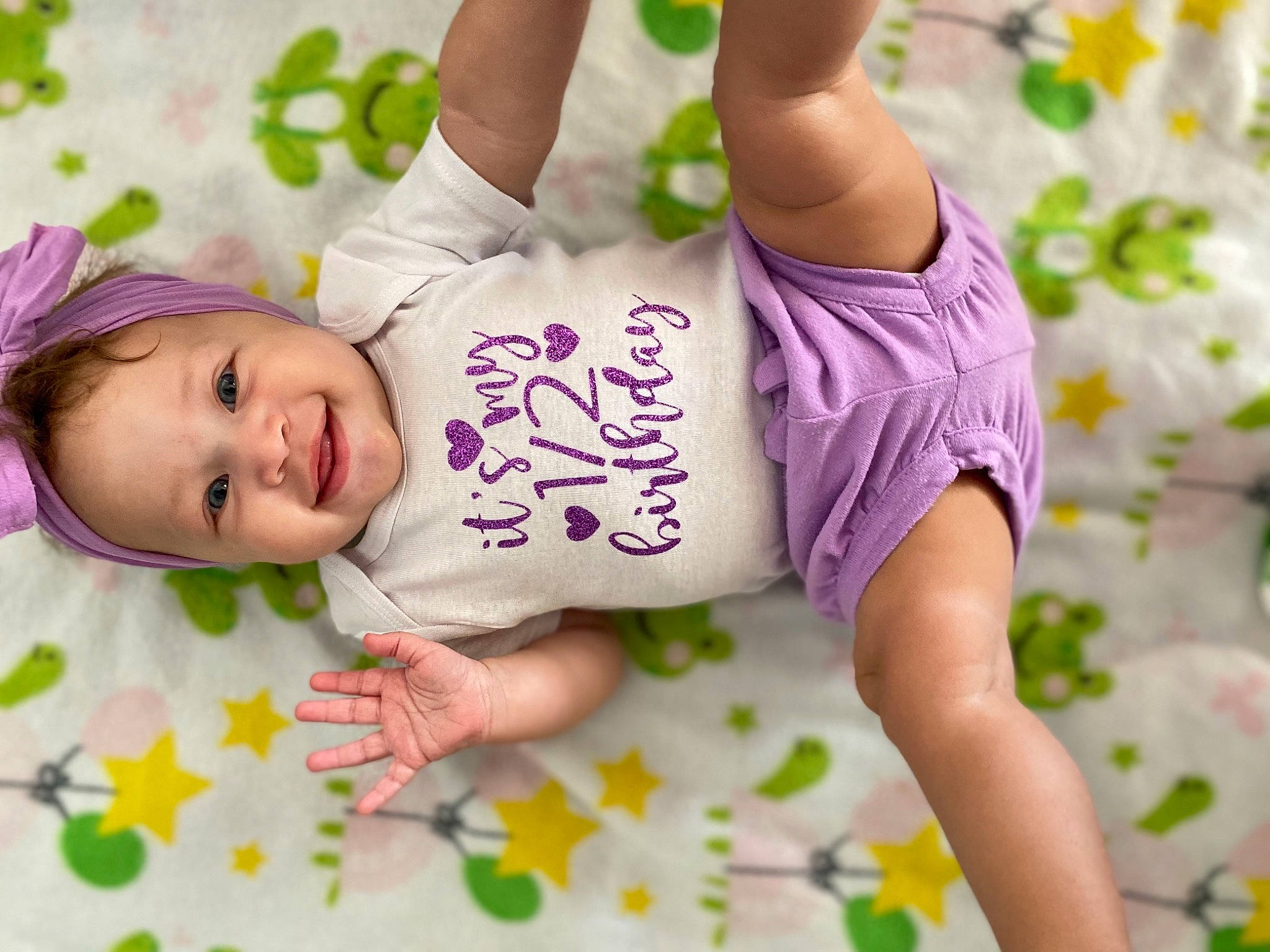 Kailani joined the competition — help win amazing prizes! arm, baby, baby_toddler_clothing, finger, font, gesture, hand, happy, human_body, joy, leg, people_in_nature, person, pink, product, purple, skin, sleeve, smile, textile