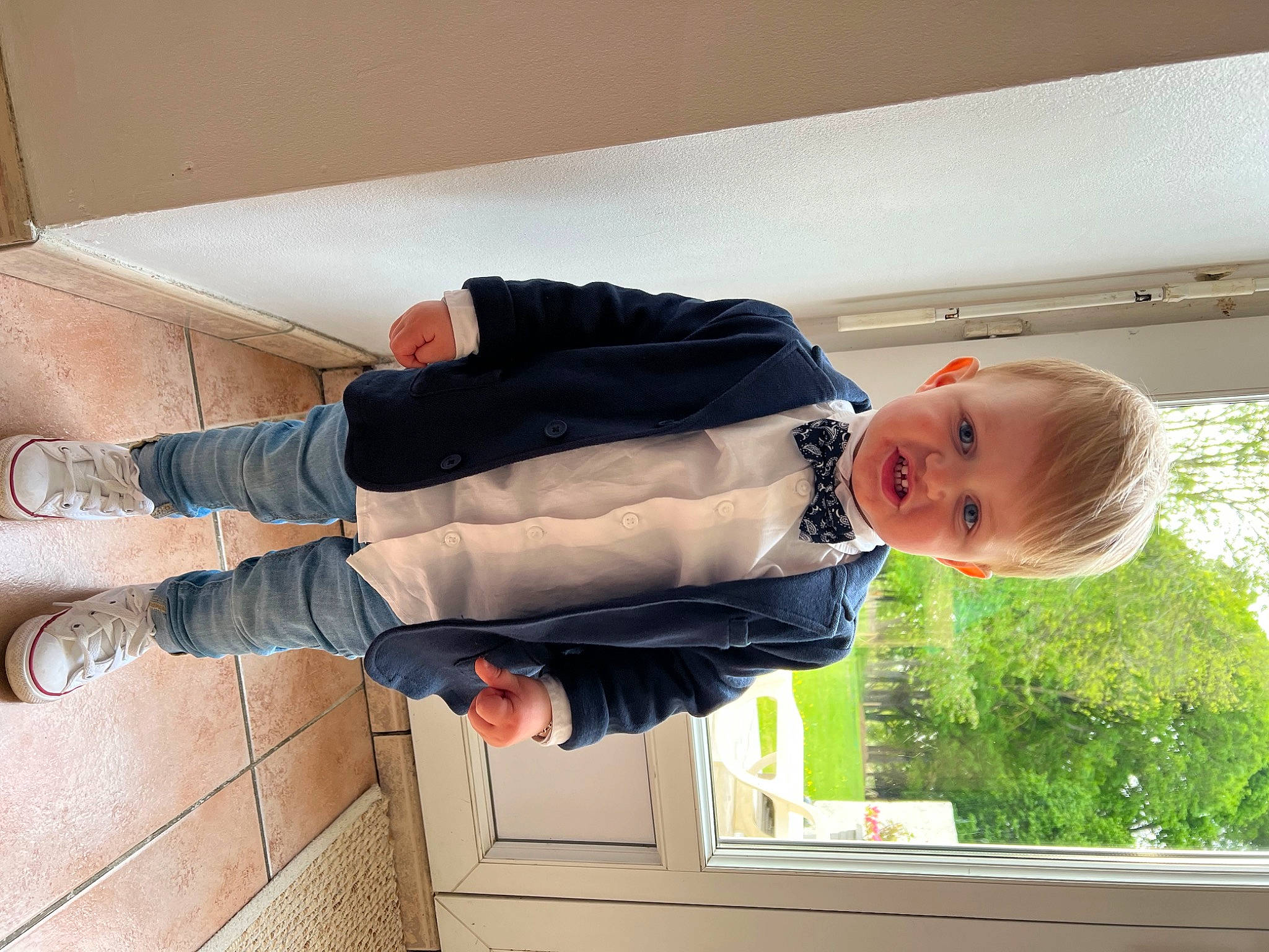 Maylonn participe au concours pour gagner de l'argent avec cette photo : baby, baby_toddler_clothing, child, comfort, flooring, gesture, happy, hat, human_body, human_leg, jacket, person, plant, sitting, sleeve, suit, sunglasses, toddler, tree, window