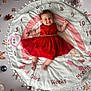 baby, child, red_dress, milestone_blanket, smile, infant, lying_down, decorations, numbers, months, weeks, days, cute, celebration, holiday, happy, face, pose, indoor, photography