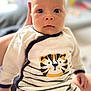 baby, infant, face, eyes, clothing, onesie, striped, tiger, hand, person, cute, portrait, soft_focus, indoor, child, expression, young, human, apparel, newborn