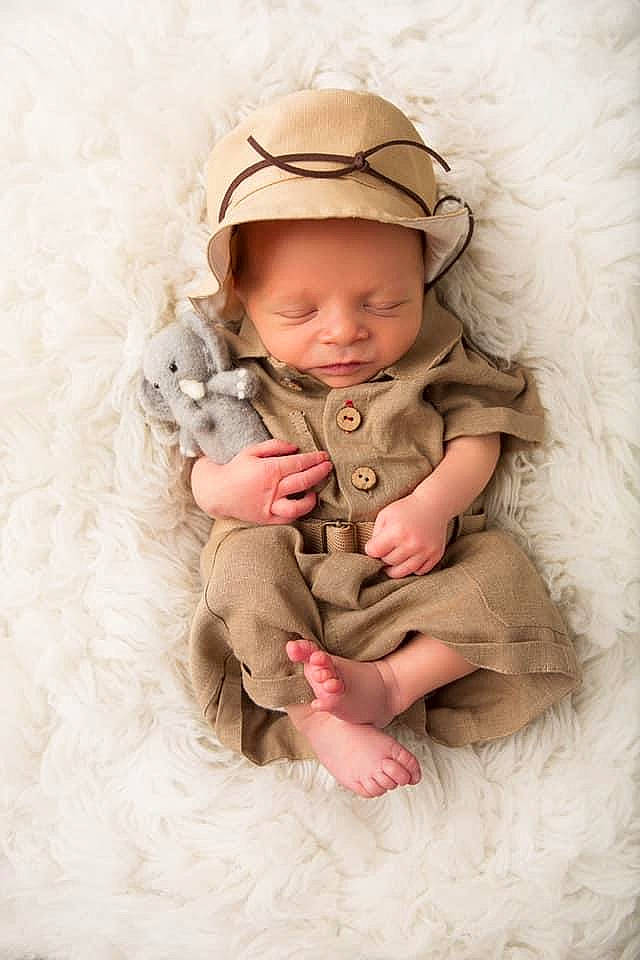 Julian is registered to the contest to win money with this photo: baby, baby_toddler_clothing, cap, child, comfort, eye, face, foot, gesture, happy, hat, headgear, headwear, linens, person, pink, skin, sleeve, smile, sun_hat