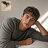 man, young_adult, portrait, face, curly_hair, brown_hair, green_eyes, gray_sweater, bed, bedroom, indoor, lounging, sitting, arm, hand, soft_lighting, cat, inset_image, watermark, photography
