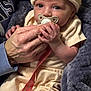 baby, infant, pacifier, hand, clothing, hat, blanket, soft_texture, closeup, face, portrait, newborn, cute, cozy, warm, person, skin, holding, indoor, expression