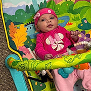 Tyler Sue is registered to the contest to win money with this photo: baby, carpet, child, colorful, cute, dinosaur_print, hand, headband, indoor, infant, legs, lying_down, pacifier_clip, pink_clothing, play_mat, portrait, smile, toy, toy_bar, wide_eyes