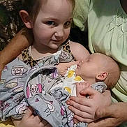 Delihla is registered to the contest to win money with this photo: adult, affection, baby, blanket, child, closeup, clothing, cuddling, family, hands, holding, indoor, infant, photography, portrait, safe, seated, siblings, sleeping, smiling