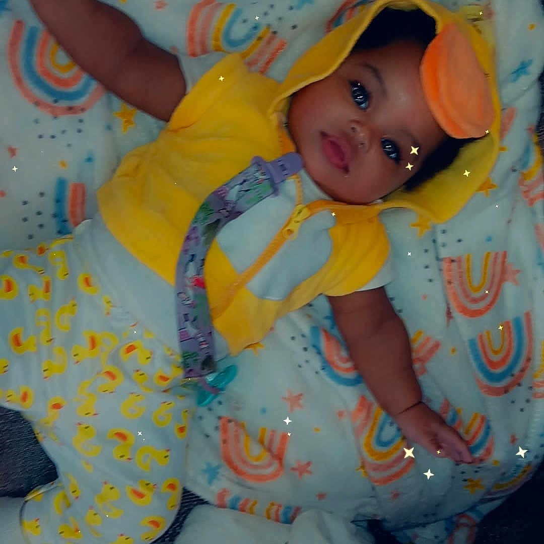 Promise joined the competition — help win amazing prizes! baby, child, infant, smiling, lying_down, yellow_outfit, hood, costume, orange_ears, blanket, rainbows, stars, sparkles, pacifier, toy, bedtime, portrait, indoor, colorful, cute