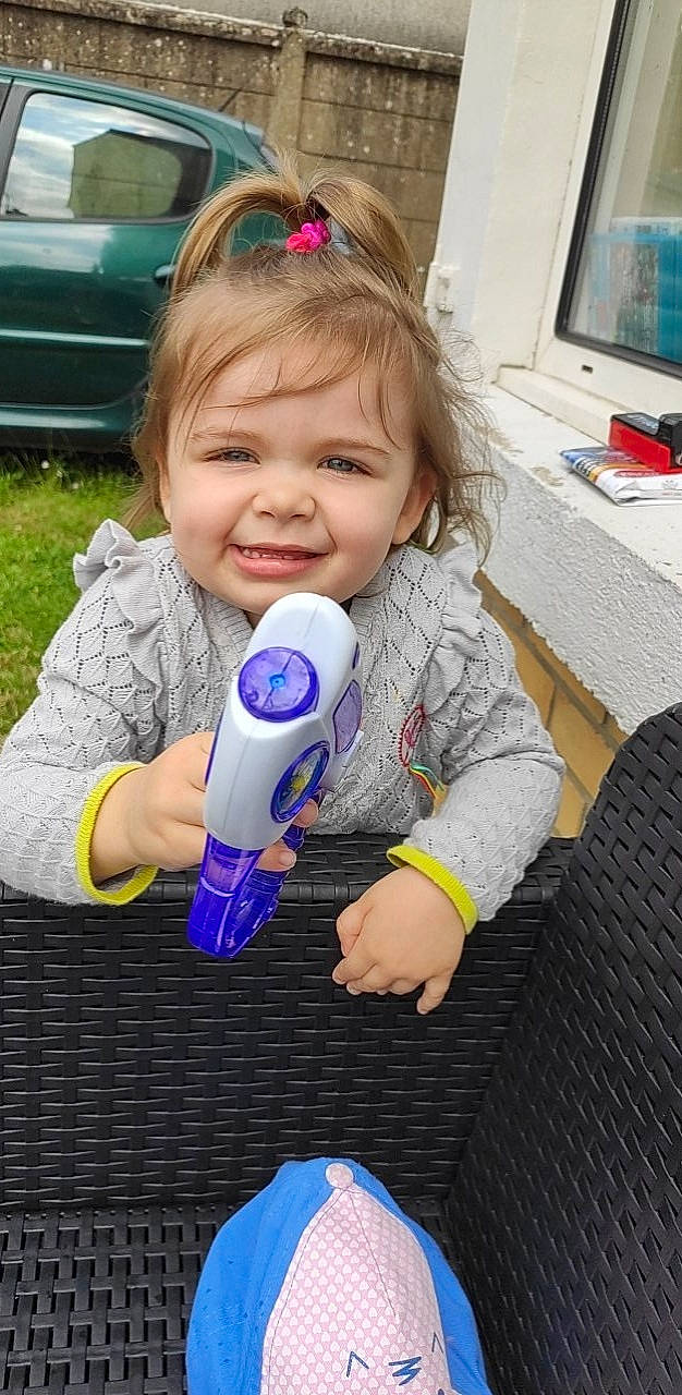 Chloé participe au concours pour gagner de l'argent avec cette photo : baby, baby_toddler_clothing, blue, child, computer_keyboard, computer_monitor, drinkware, electronic_device, finger, fun, grass, hand, happy, joy, person, skin, smile, snapshot, standing, television