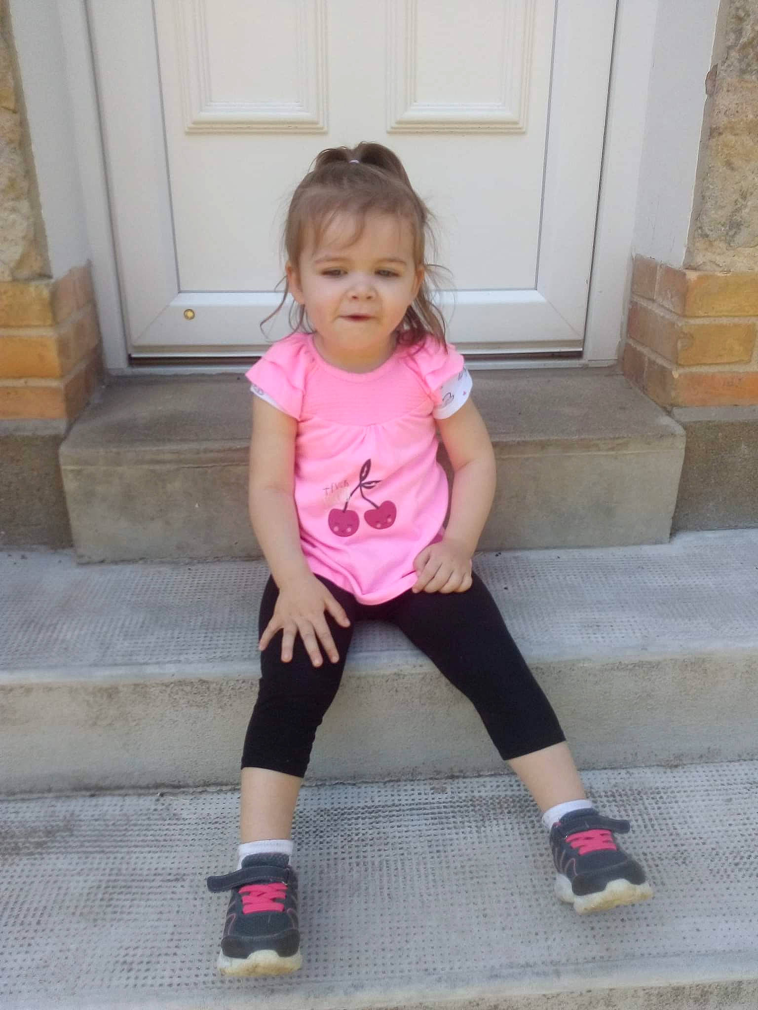 Chloé participe au concours pour gagner de l'argent avec cette photo : arm, baby_toddler_clothing, door, dress, finger, hair, hand, head, knee, neck, outerwear, person, pink, shorts, sleeve, sneakers, sock, t_shirt, thigh, toddler