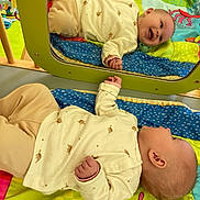 Tayssa a rejoint le concours — aidez-le/la à gagner de superbes lots ! baby, infant, mirror, reflection, play_mat, colorful, smiling, lying_down, clothing, turtle_print, wooden_frame, green_frame, happy, child, indoor, soft_toys, bright_colors, cute, casual, peaceful