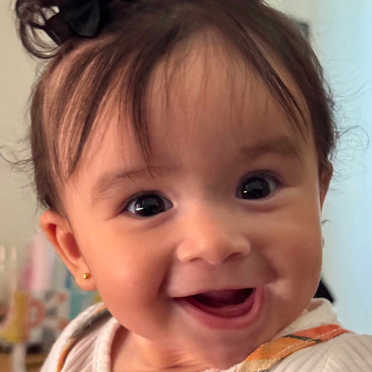 Cecilia joined the competition — help win amazing prizes! baby, background_blur, bright_eyes, child, closeup, clothing, cute, face, fingernails, hair_bows, hand, happy, indoor, infant, joyful, orange_outfit, person, portrait, smiling, white_shirt