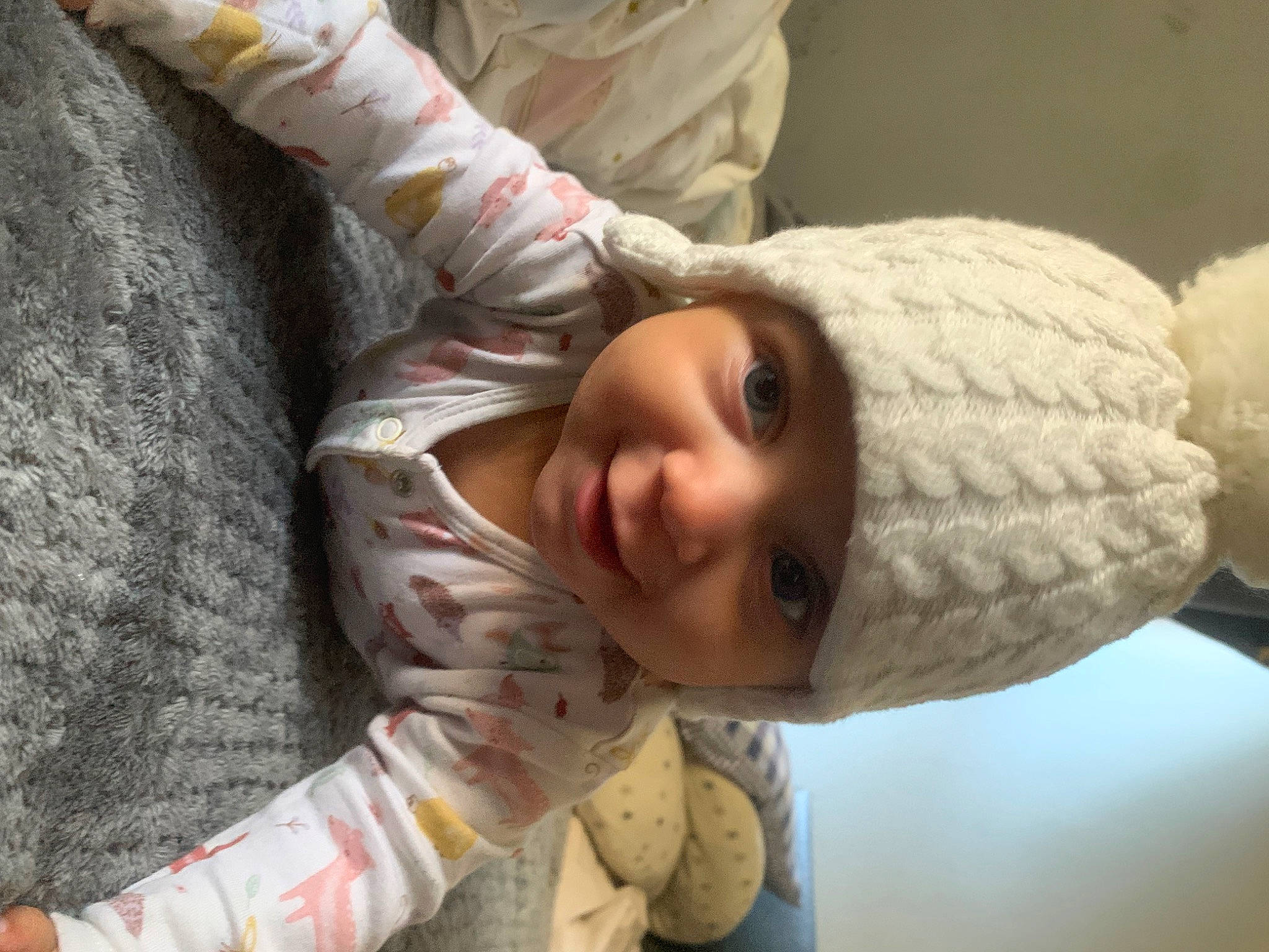 Eva is registered to the contest to win money with this photo: baby, baby_toddler_clothing, cheek, comfort, elbow, eye, eyelash, face, gesture, hair, happy, head, headwear, human_body, joy, linens, lip, mouth, nose, person