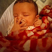 Everleigh is registered to the contest to win money with this photo: baby, infant, sleeping, pacifier, blanket, red_blanket, hand, face, closed_eyes, newborn, cozy, soft_fabric, bed, rest, child, cute, warm, comfort, indoors, portrait