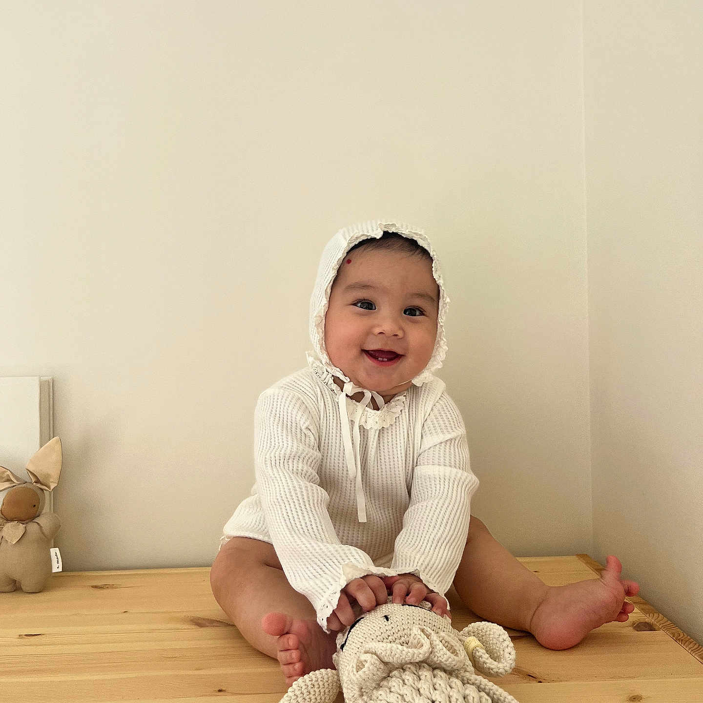 Kasaij is registered to the contest to win money with this photo: baby, babylaughing, blanket, bodypart, bonnet, clothing, face, finger, hand, happy, hardwood, hat, head, knitwear, person, photography, portrait, sitting, smile, wood