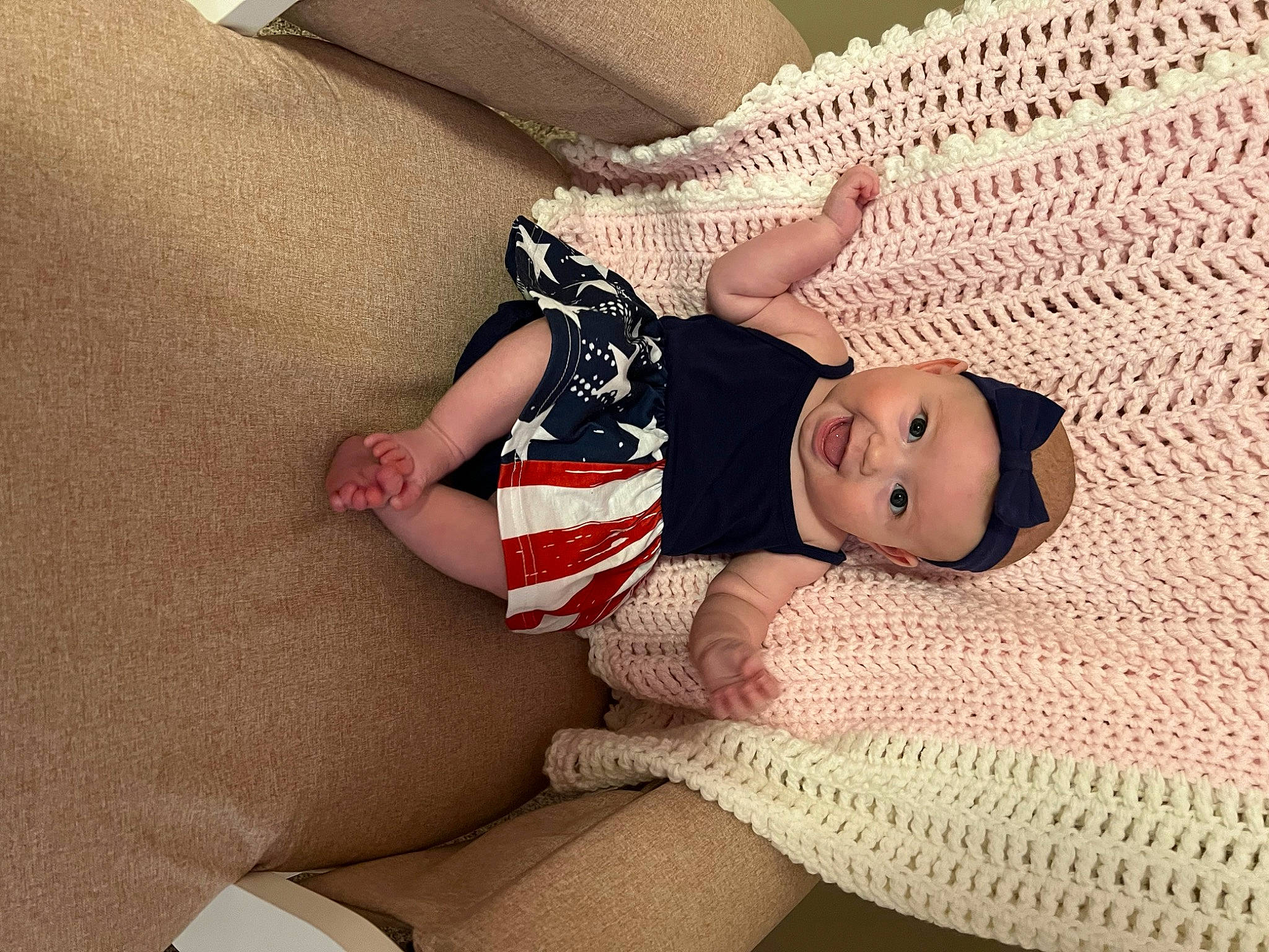 Juliana is registered to the contest to win money with this photo: arm, baby, baby_toddler_clothing, comfort, facial_expression, finger, floor, flooring, hand, headwear, human_body, knee, leg, linens, pattern, person, skin, sleeve, sock, thigh