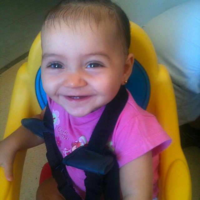 Louna Kalousdian participe au concours pour gagner de l'argent avec cette photo : baby, bright_colors, cheerful, child, cute, face, hair_tie, happy, high_chair, indoor, person, pink_shirt, playful, seat_belt, secure, sitting, small_child, smile, toddler, young_child