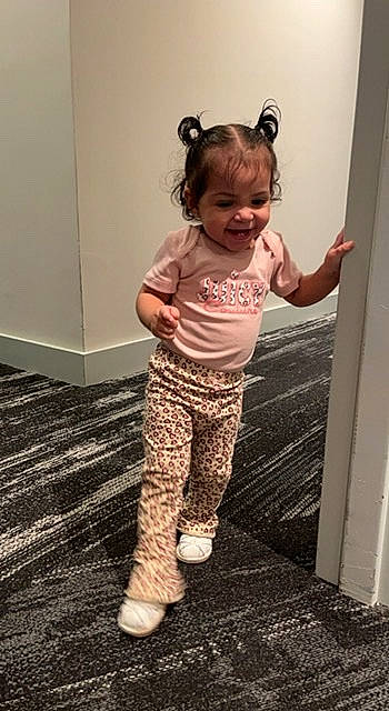 Renessme is registered to the contest to win money with this photo: baby, baby_toddler_clothing, child, floor, flooring, foot, fun, gesture, hairstyle, happy, human_leg, joint, joy, leg, pattern, person, sleeve, t_shirt, thigh, toddler