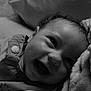baby, child, smile, face, curly_hair, blanket, fabric, closeup, portrait, happy, infant, couch, soft_texture, cozy, clothing, button, indoor, head, young_child, black_and_white