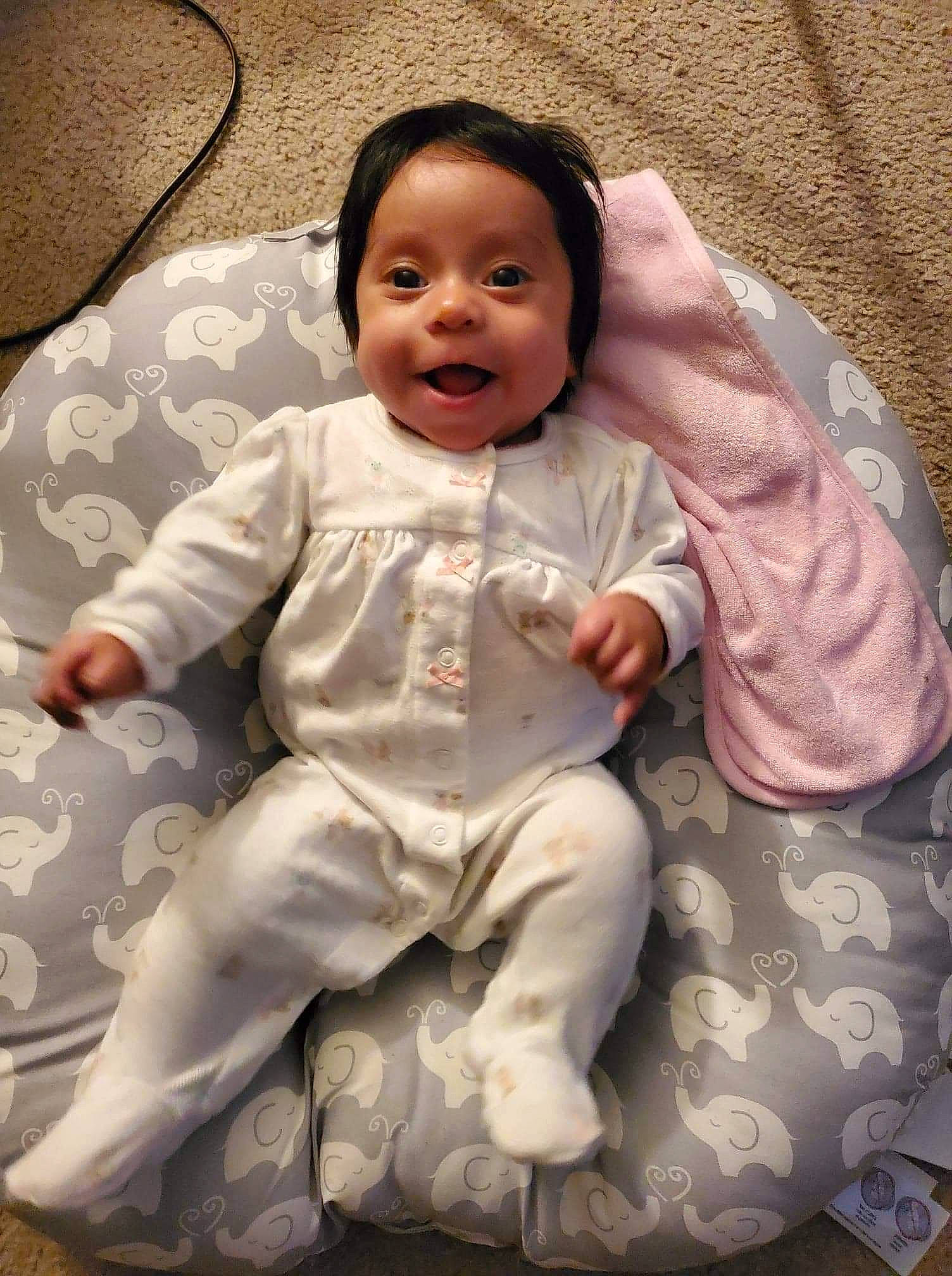 Lorelai is registered to the contest to win money with this photo: baby, baby_products, baby_toddler_clothing, cheek, child, comfort, face, foot, fun, happy, head, linens, outerwear, person, pink, sitting, skin, sleeve, smile, t_shirt