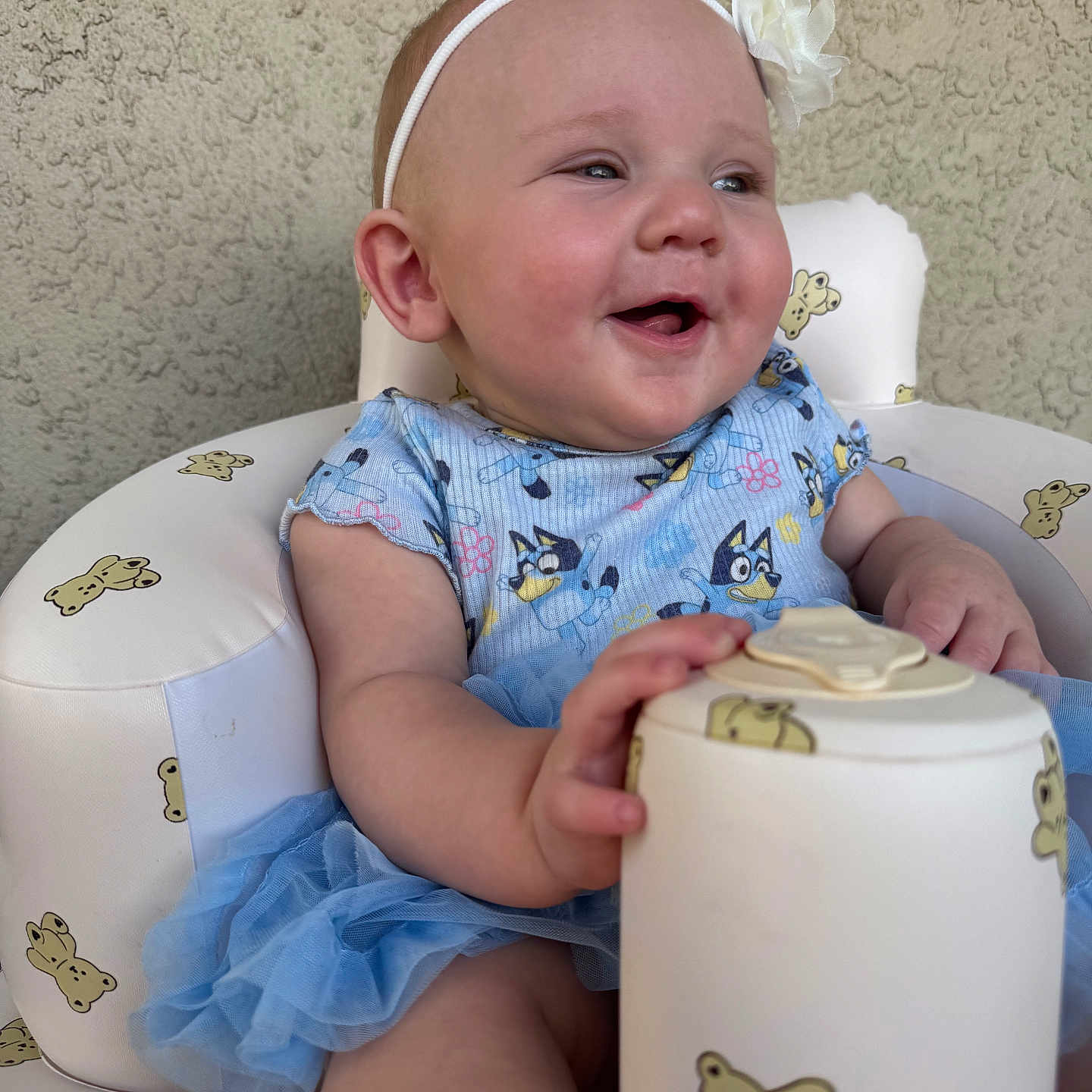 Raven joined the competition — help win amazing prizes! baby, blue_dress, child, closeup, container, fingers, flower_accessory, hand, happy_expression, headband, infant_chair, legs, lid, portrait_photo, skin, smiling, teddy_bear_pattern, textured_wall, toes, tutu_skirt