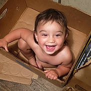 Gwendolyn joined the competition — help win amazing prizes! broken_box, cardboard_box, child, cute, face, floor, hair, happy, home, indoor, joy, person, playful, sitting, skin, smiling, snack_box, toddler, wooden_floor, young_child