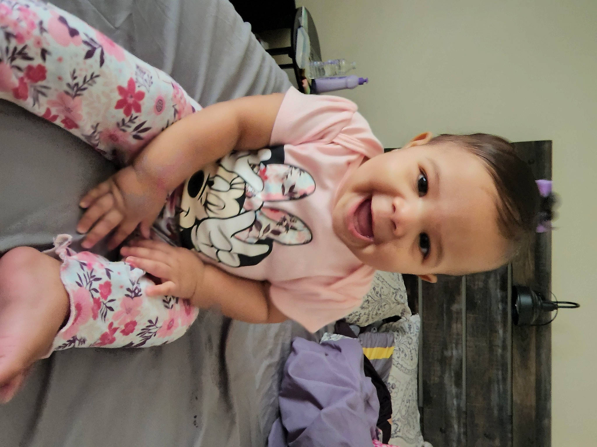 Maria is registered to the contest to win money with this photo: baby, baby_toddler_clothing, cheek, child, comfort, couch, eyelash, facial_expression, finger, fun, happy, joint, person, pink, room, sitting, skin, sleeve, smile, t_shirt