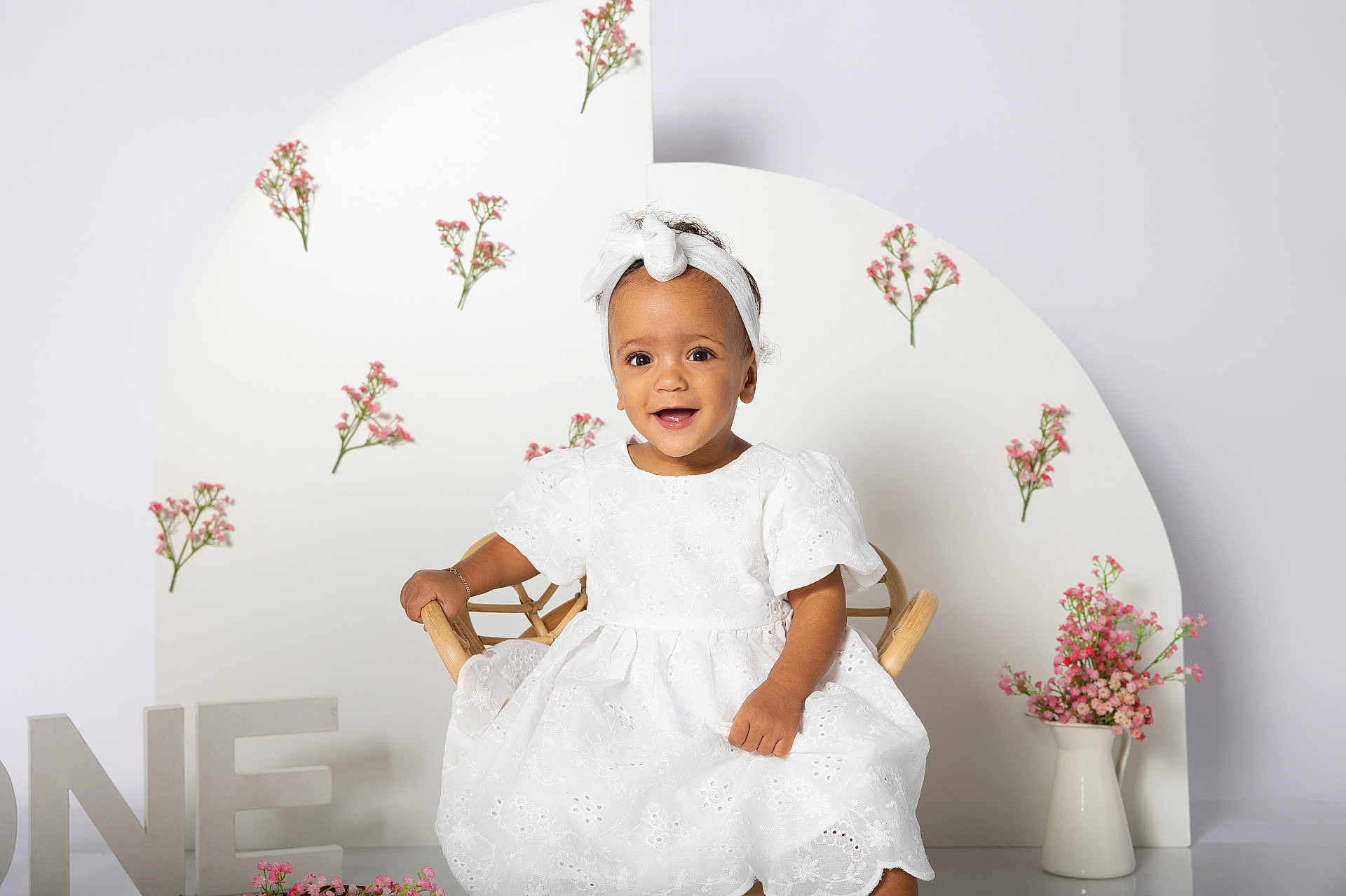 Anastasia a rejoint le concours — aidez-le/la à gagner de superbes lots ! baby, birthday, celebration, chair, child, cute, decor, flowers, happy, headband, indoor, one_year, pastel, pink_flowers, portrait, smiling, toddler, vase, white_dress, wicker_chair