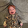 Melody is registered to the contest to win money with this photo: baby, infant, leopard_print, onesie, headband, bow, smiling, happy, sitting, couch, fabric, texture, indoors, child, person, cute, clothing, portrait, young, cozy