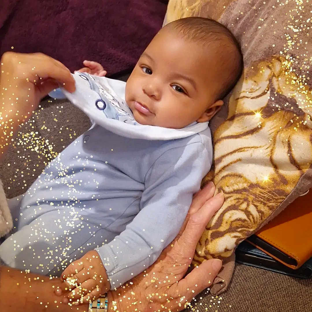 Khamis a rejoint le concours — aidez-le/la à gagner de superbes lots ! baby, blanket, clothing, couch, cozy, face, glitter, hand, indoor, infant, onesie, person, pillow, portrait, resting, skin, sparkles, tiger_print, warm, watch
