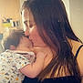 affection, baby, black_top, child, clothing, cozy, curtains, face, furniture, hair, heart_graphic, holding, indoor, kiss, love, mother, onesie, peaceful, sleeping, woman