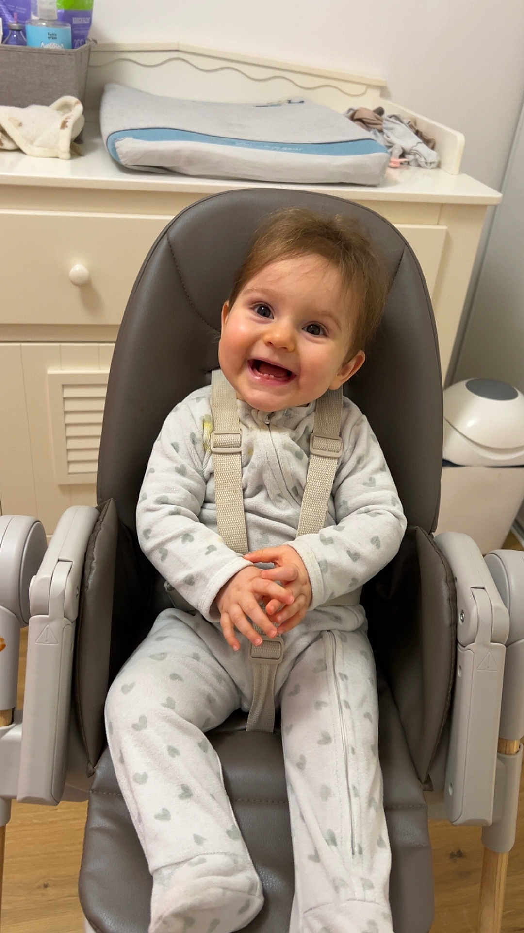 Lou a rejoint le concours — aidez-le/la à gagner de superbes lots ! baby, baby_care, baby_gear, changing_pad, child, cute, face, furniture, happy, heart_pattern, high_chair, indoor, infant, nursery, onesie, person, seat, smiling, straps, wood_floor