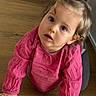 Lou participe au concours pour gagner de l'argent avec cette photo : toddler, child, baby, pink_clothing, long_sleeve, hair_tie, curly_hair, floor, wooden_floor, crawling, indoor, person, young_child, cute, face, expression, looking_up, skin, hand, casual_wear