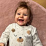 baby, bear_design, cute, eyes, face, hair, hand, happy, indoor, infant, laughing, lying_down, onesie, pajamas, pink_rug, portrait, skin, smiling, teeth, wooden_floor