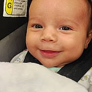 Mason joined the competition — help win amazing prizes! baby, smiling, close_up, blanket, car_seat, face, infant, child, seatbelt, safety_label, portrait, cute, happy, indoors, skin, head, eyes, clothing, young_child, baby_boy