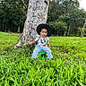 Mateo joined the competition — help win amazing prizes! toddler, child, hat, tree, grass, greenery, outdoor, nature, dinosaur_shirt, pants, stool, sitting, young_child, park, daylight, forest, leaves, casual_clothing, portrait, cute
