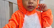 Mateo is registered to the contest to win money with this photo: toddler, child, costume, fox, orange, white, crib, furniture, indoor, person, cute, portrait, expression, baby, clothing, headwear, hand, face, curious, young