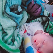 Charlotte joined the competition — help win amazing prizes! baby, sleeping, blanket, pillow, heart_pattern, indoor, cozy, infant, soft_fabric, colorful, rest, peaceful, child, face, head, person, comfort, nap, home, cushion