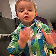 Gabin participe au concours pour gagner de l'argent avec cette photo : background, boy, casual_wear, child, colorful_clothing, expression, eyes, face, hair, hand_movement, home, indoor, lighting, mickey_mouse, motion_blur, mouth, person, plaid_shirt, toddler, young_child