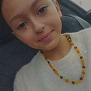 Yûna a rejoint le concours — aidez-le/la à gagner de superbes lots ! child, girl, face, smile, necklace, amber_beads, white_sweater, portrait, car_seat, seatbelt, indoor, closeup, young, casual, cute, happy, head, hair, person, emoji