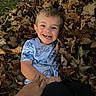 child, boy, smile, happy, leaves, autumn, outdoor, nature, play, grass, hand, casual_clothing, short_sleeves, face, young, fall, season, joy, person, fun