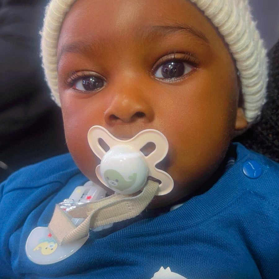 Rafel joined the competition — help win amazing prizes! apparel, baby, blue_shirt, child, close_up, clothing, cute, expression, eyes, face, hat, headwear, indoors, infant, knit_hat, pacifier, person, portrait, puma_logo, young_child