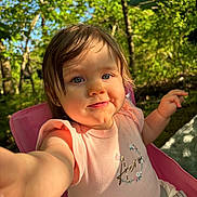 Isabella is registered to the contest to win money with this photo: toddler, child, selfie, outdoor, nature, trees, greenery, sunlight, pink_chair, smile, face, cute, baby, summer, daylight, happy, person, clothing, shirt, portrait