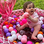 Isabella joined the competition — help win amazing prizes! baby, child, clothing, colorful, cute, fun, grass, happy, infant, inflatable_pool, outdoor, person, pink, plastic_balls, play, sitting, skin, summer, toy, young_child